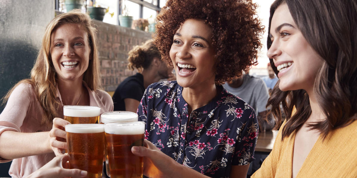 Three ladies holding glasses of beer